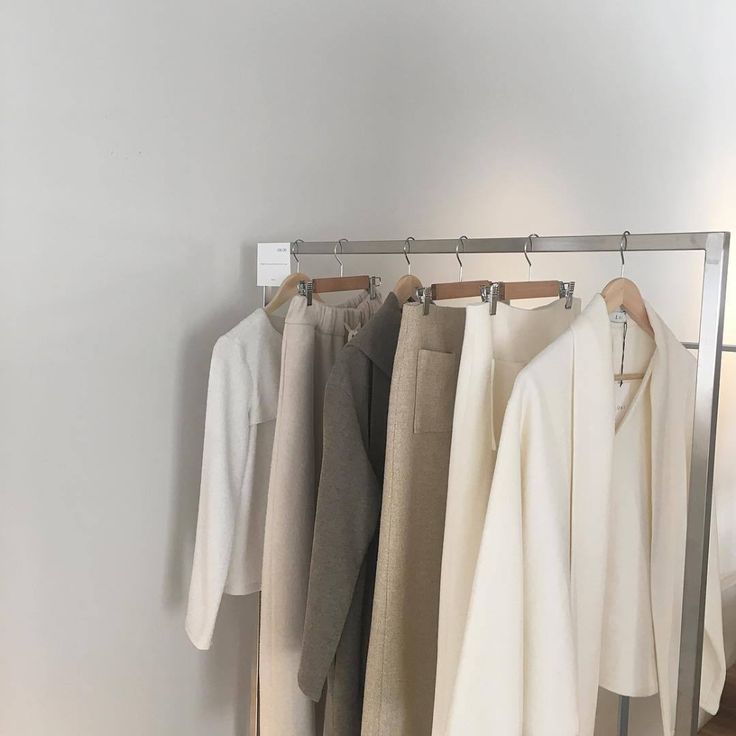 Neutral-coloured clothing on how to create a minimalist wardrobe clothing rack showing a balanced wardrobe colour palette.