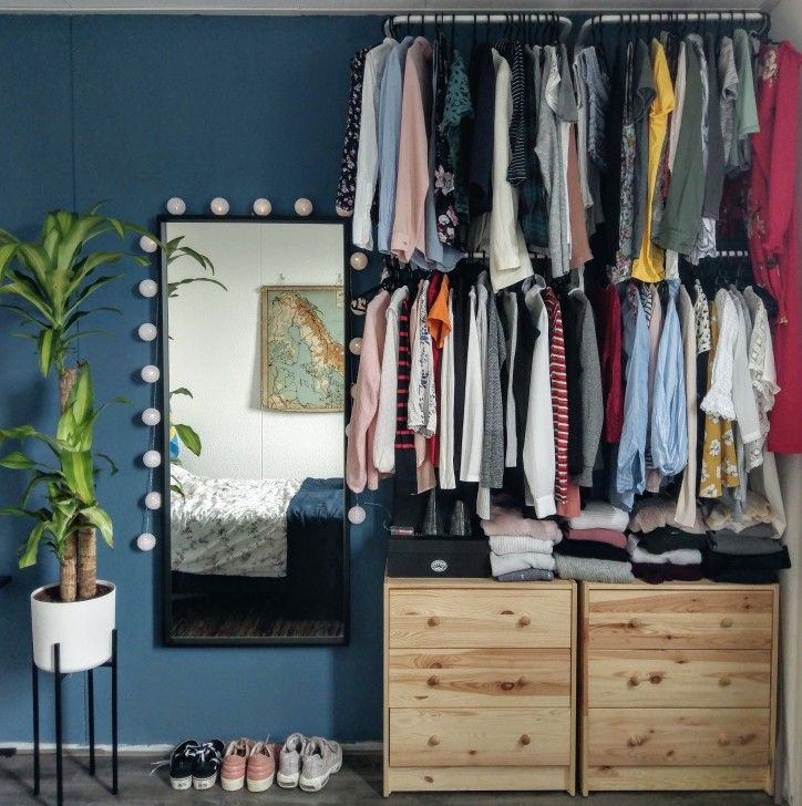 Open floating wardrobe design with drawers and mirror for a modern minimalist bedroom.