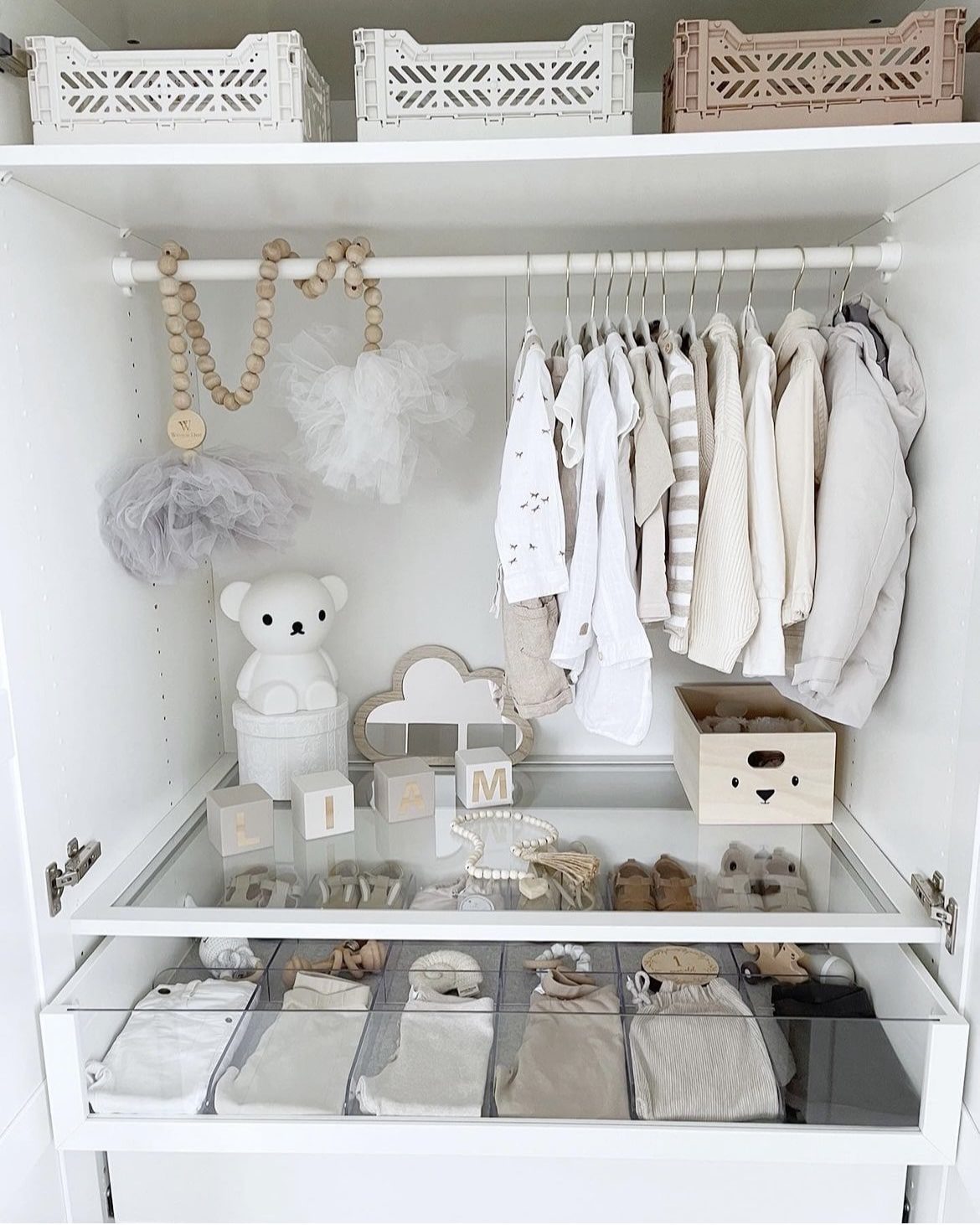 Minimalist wardrobe for nursery with neutral baby clothes and safe storage design